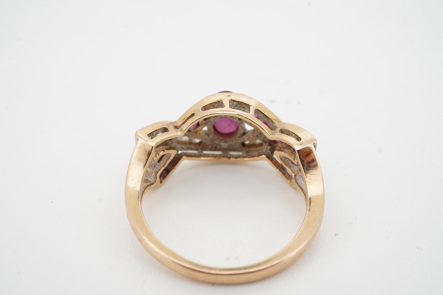 A ruby and diamond ring, of woven design, centring on an oval ruby, to a band set with calibré-cut rubies and brilliant-cut diamonds, mounted in gold, size N1/2, stamped 18K, gross weight 4 grams